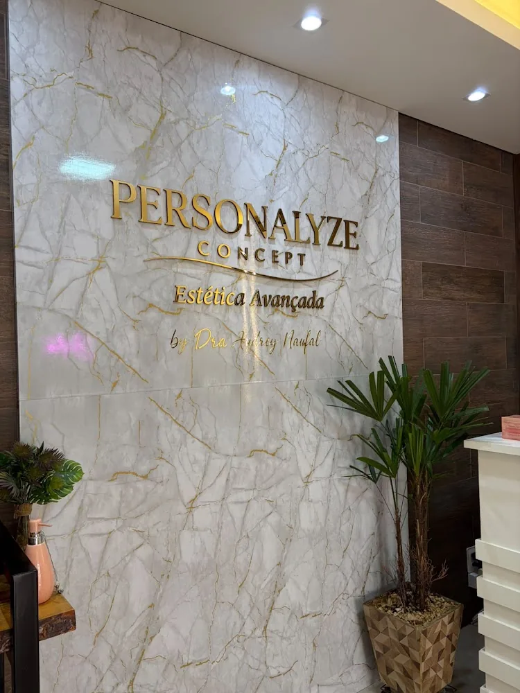 Parede de mármore com a marca Personalyze Concept em letras douradas