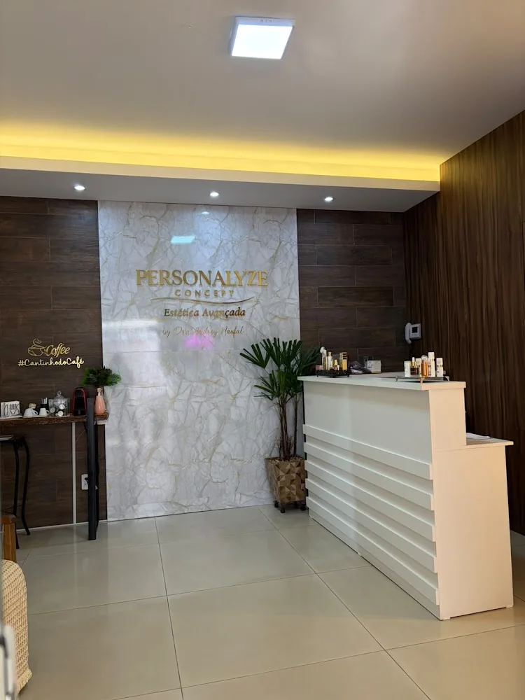 Recepção da Personalyze Concept com parede de mármore, balcão branco e cantinho do café