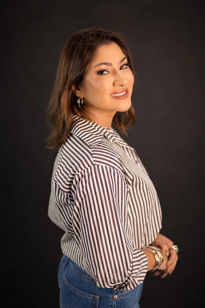 Dra. Audrey Naufal em retrato com camisa listrada, sorrindo